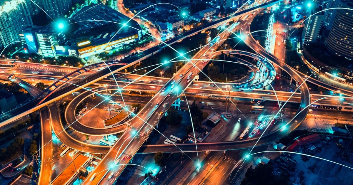 Mobilität der Zukunft Eine Autobahnkreuzung mit Zubringern in der Nacht mit symbolischen Linien für die Vernetzung der Fahrzeuge